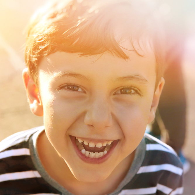 Boy in striped shirt, smiling at the camera | SungateKids | Child Abuse Awareness, Support & Advocacy
