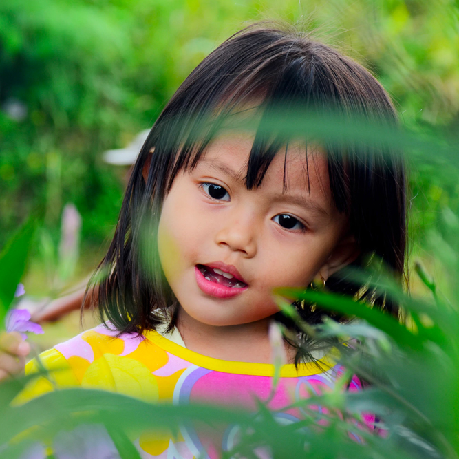 Young girl looking at leafy plants | SungateKids | Child Abuse Awareness, Support & Advocacy