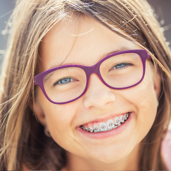 Girl with braces and purple glasses, smiling at the camera | SungateKids | Child Abuse Awareness, Support & Advocacy