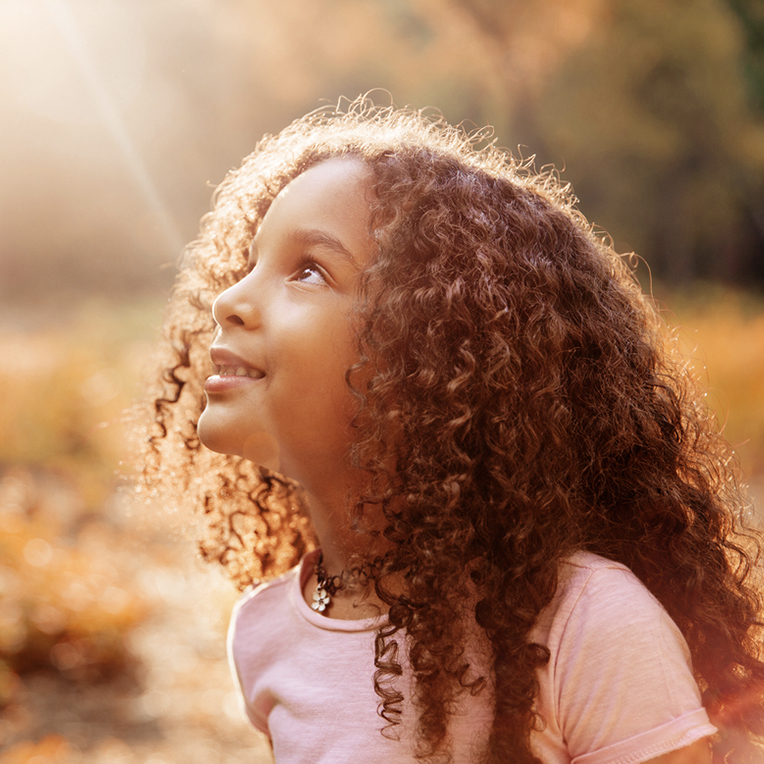Young girl looking up at sunshine | SungateKids | Child Abuse Awareness, Support & Advocacy